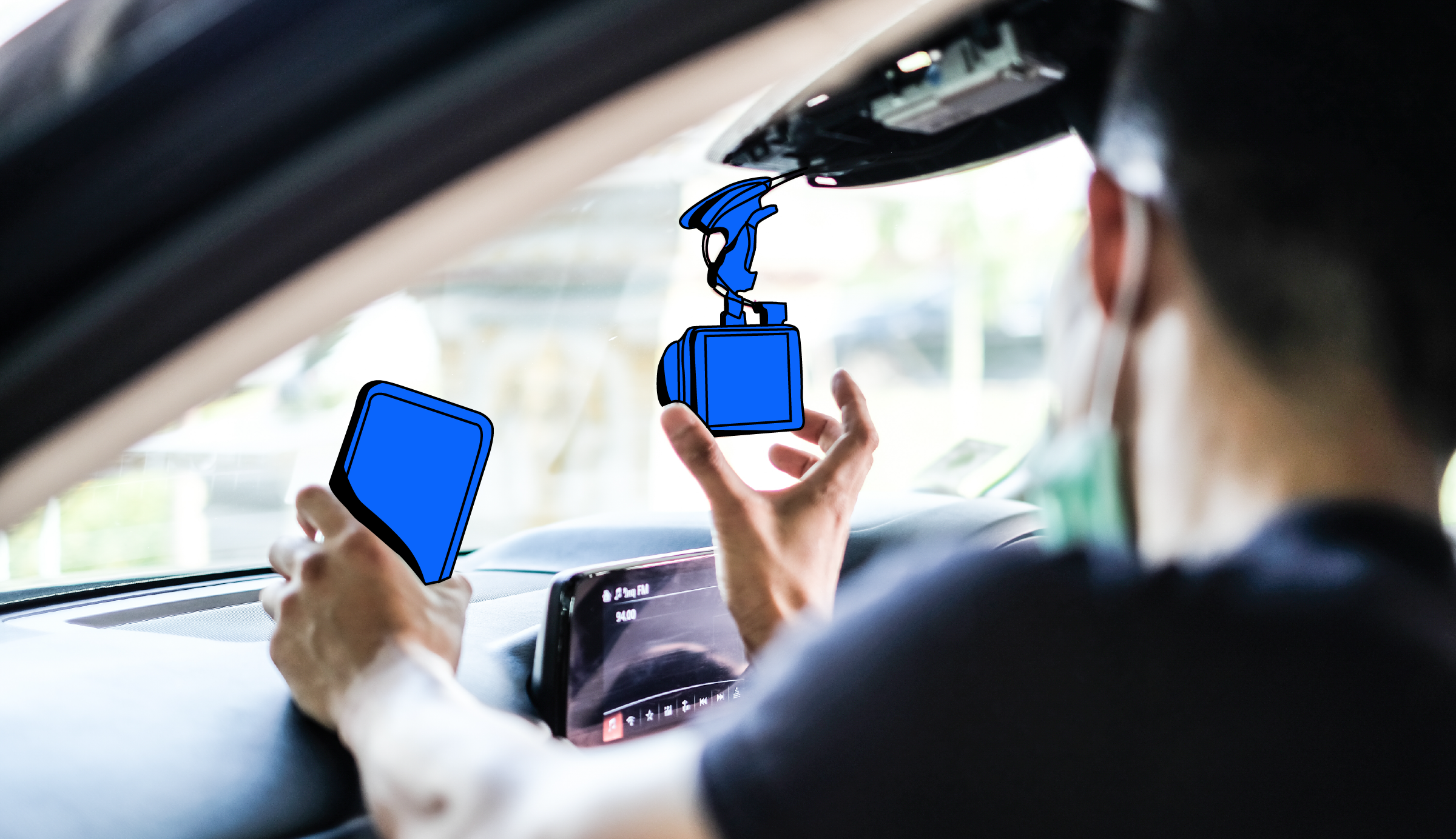 Professional installing a dash cam in a car's interior near the rear-view mirror.