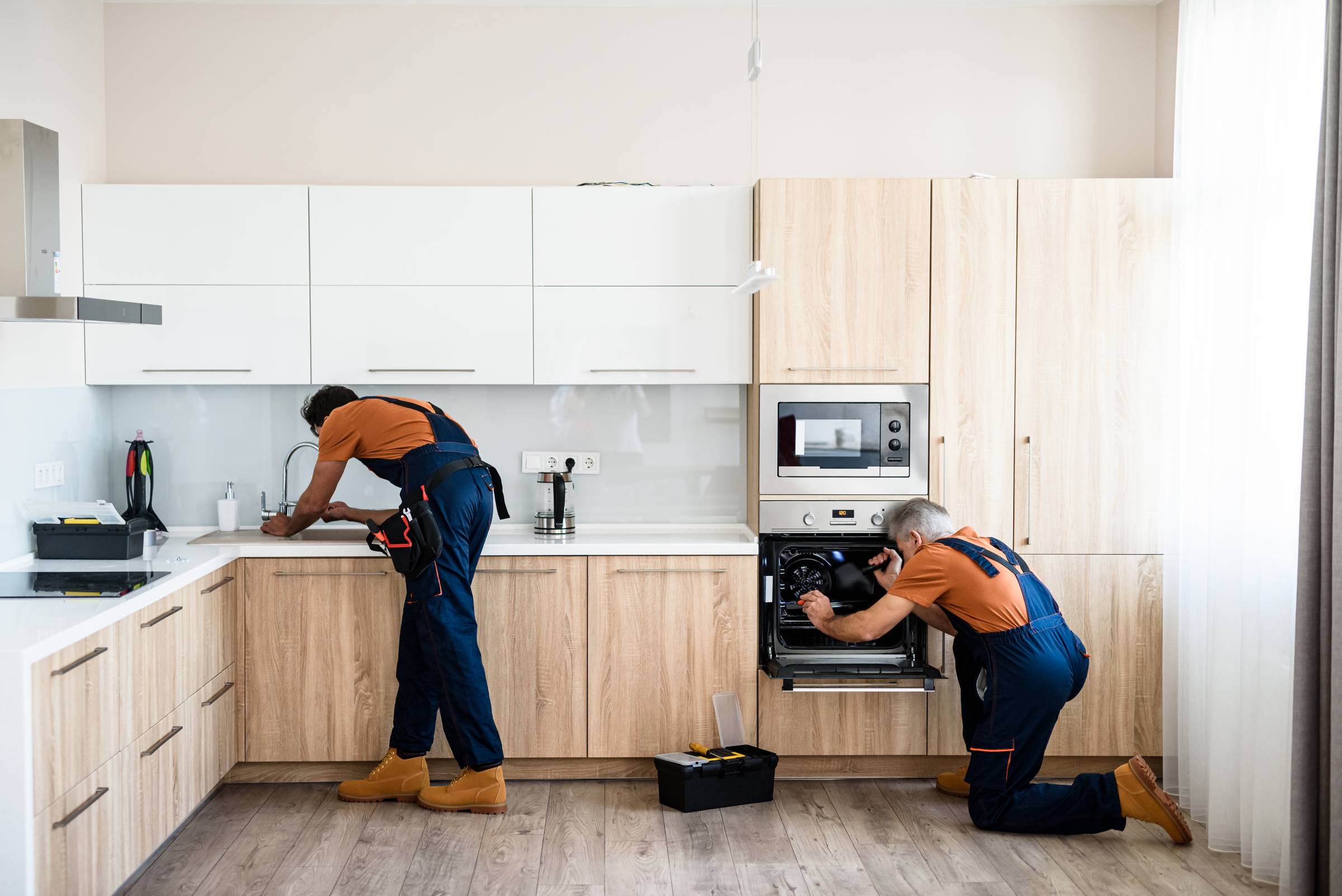 handymen installing kitchen appliances