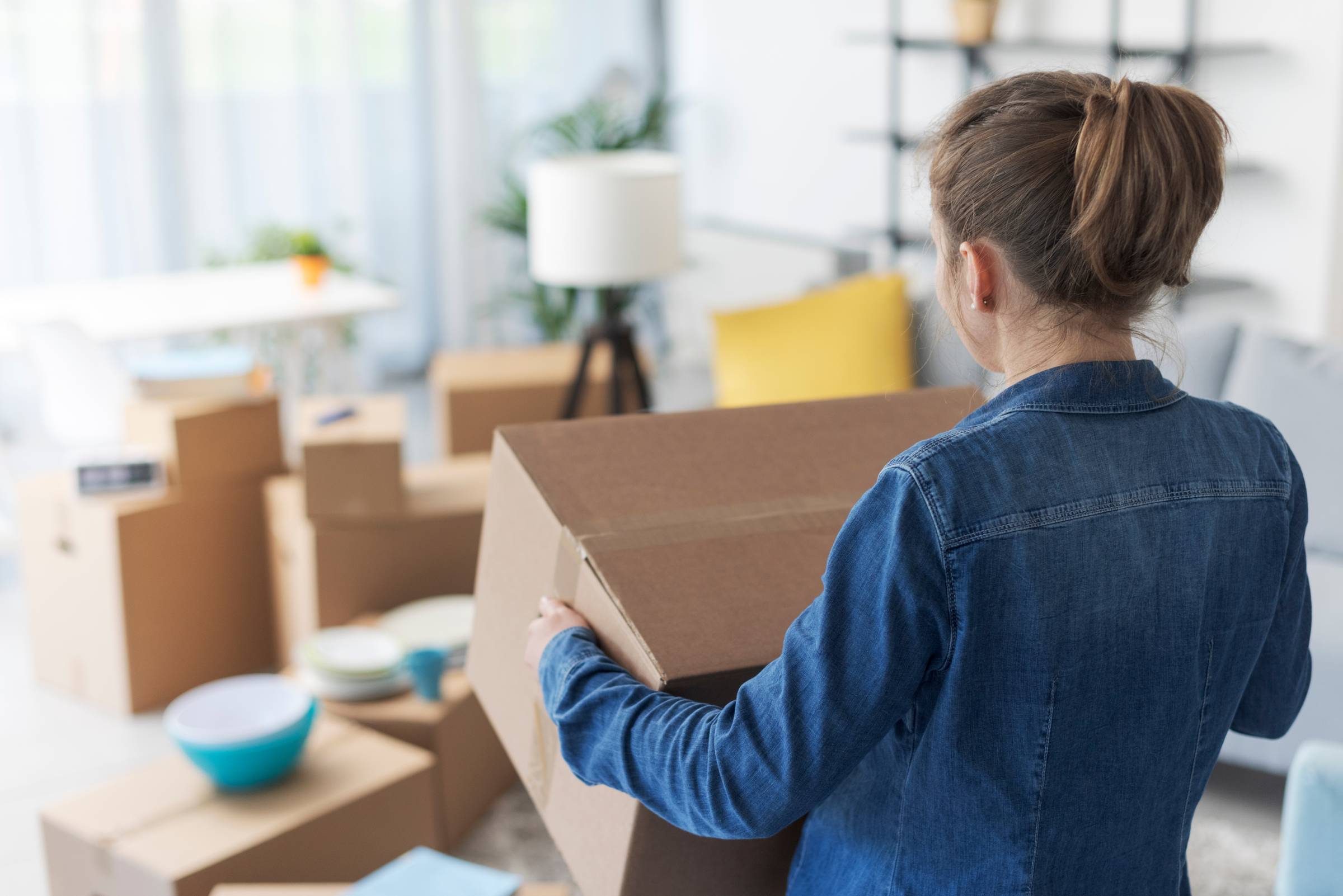 a woman carrying a moving box