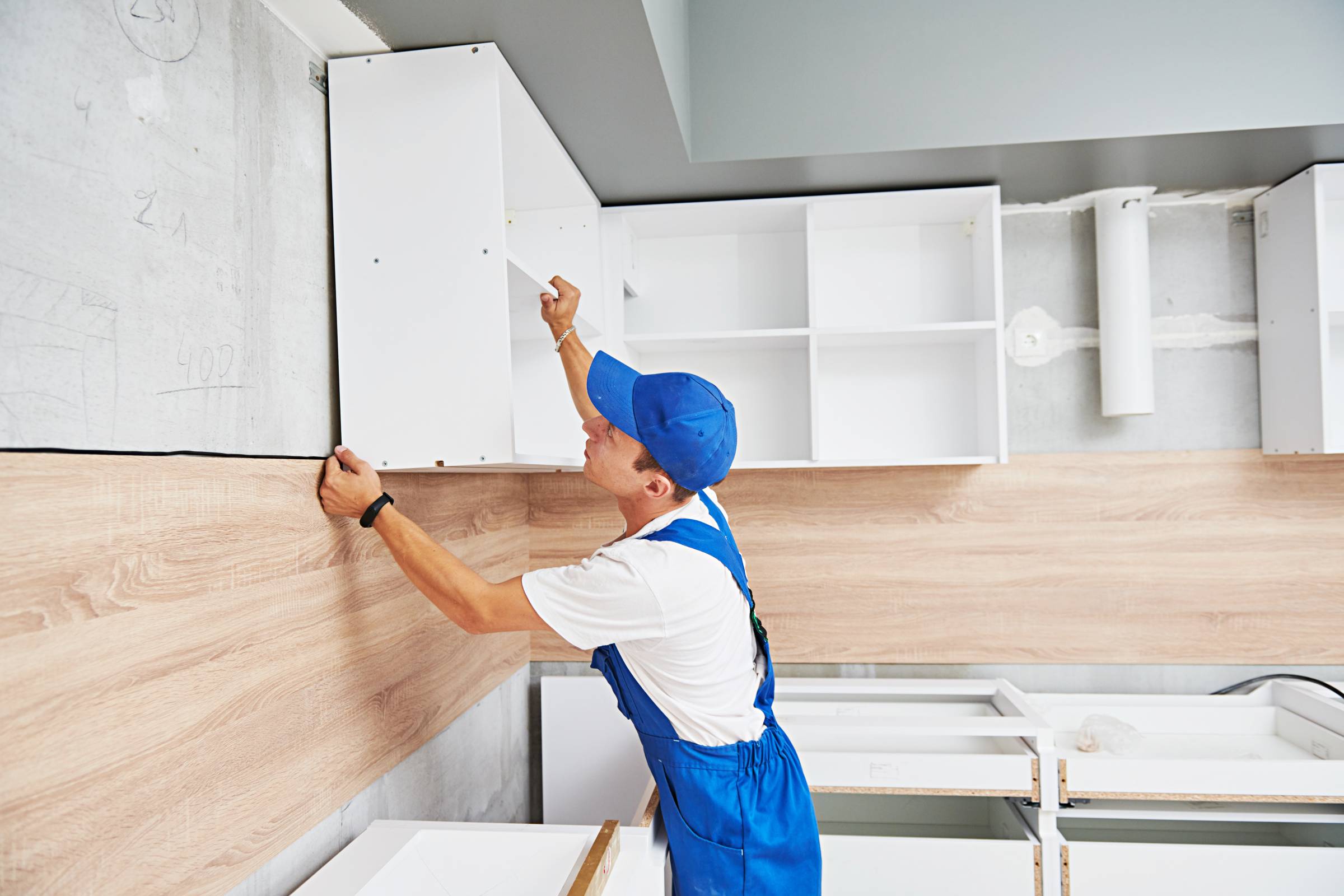 a man installing IKEA kitchen cabinets