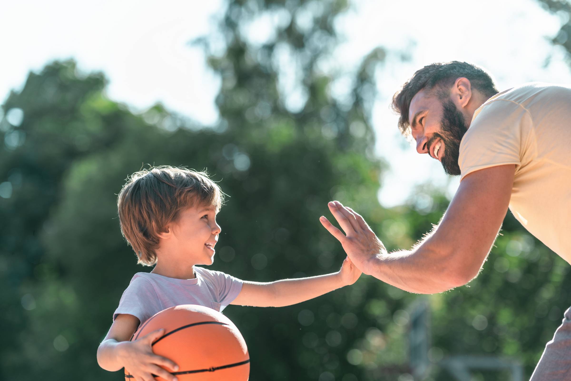 a father playing basketball with his child