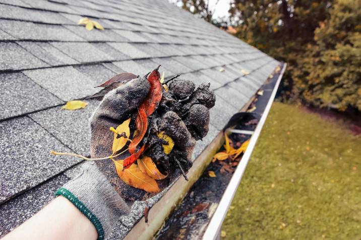 Cleaning leaves and debris out of gutters before winter