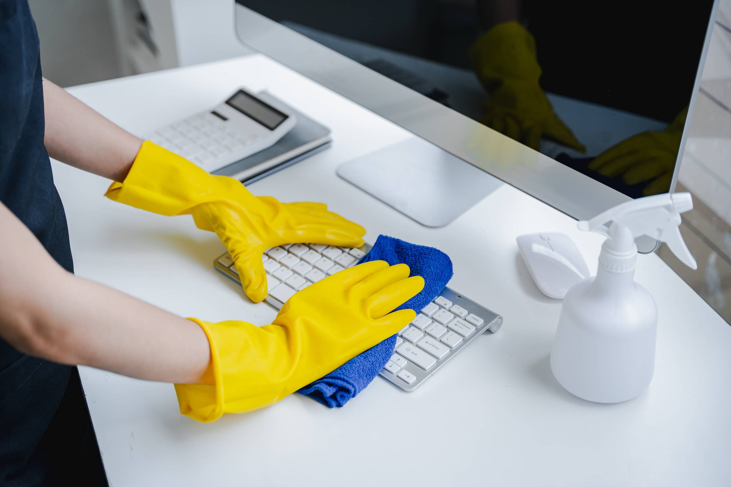 a woman cleaning workstation equipment