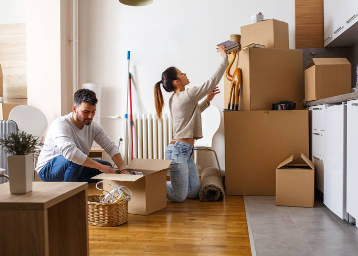 young couple packing boxes in living room