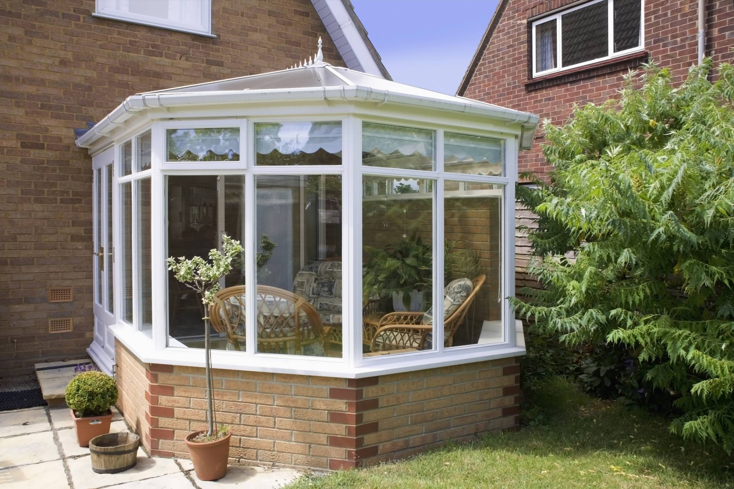 a white conservatory with a brick base