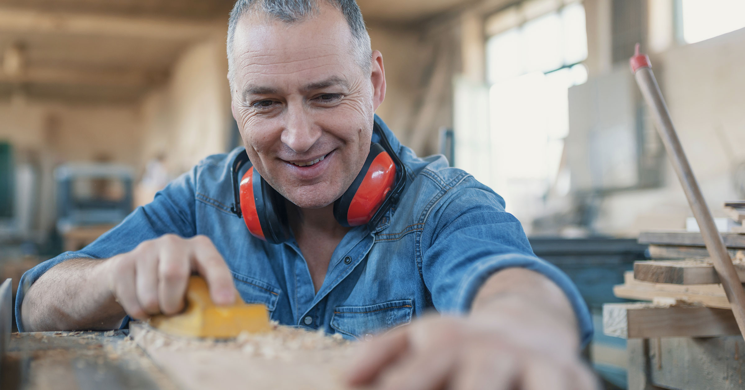 A close-up image of a carpenter sanding a plank of wood representing carpenters near me.