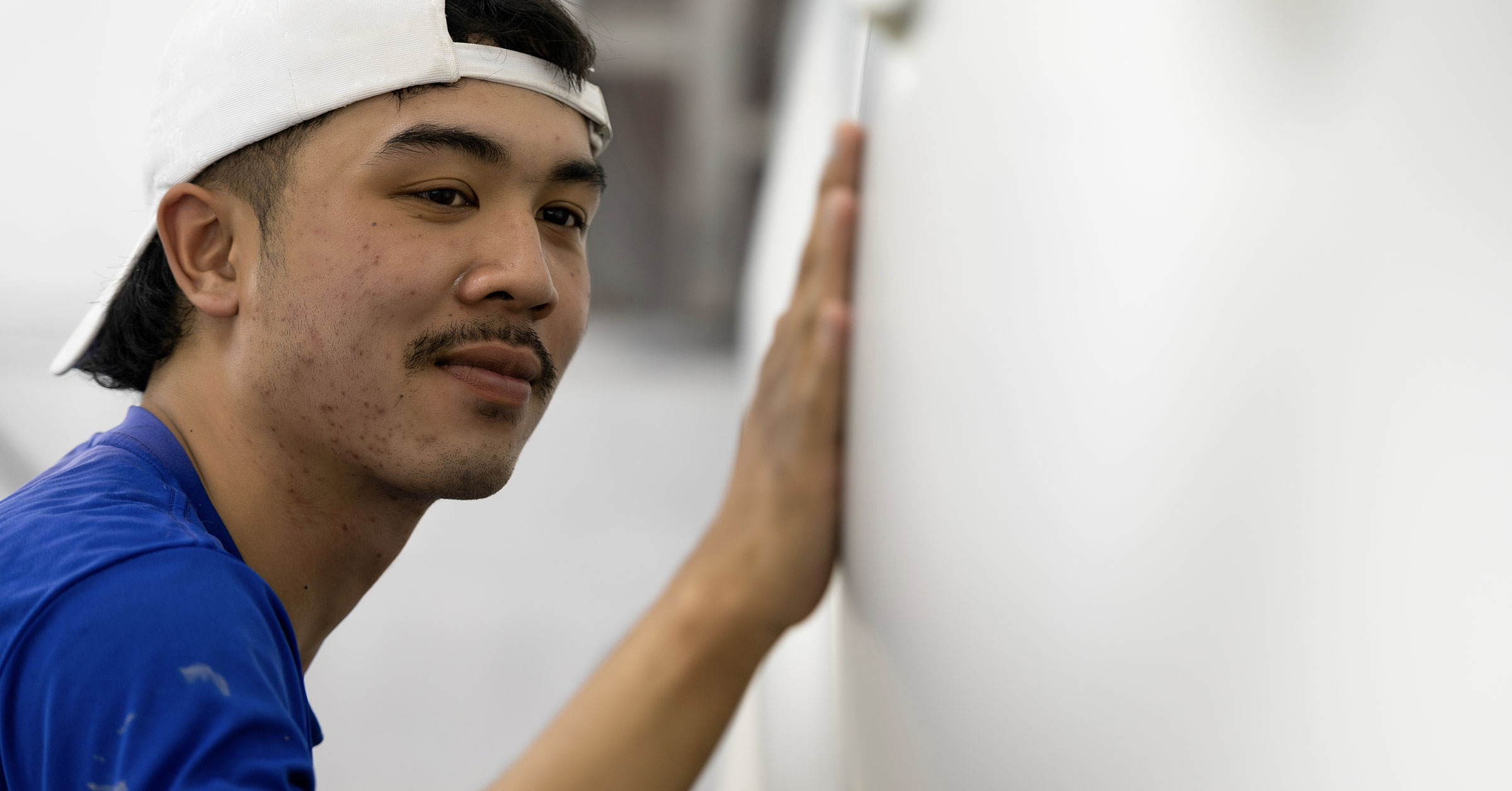 A close up image of a mechanic inspecting his work on a car body