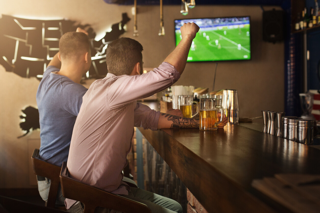 two men cheering inside a sports bar