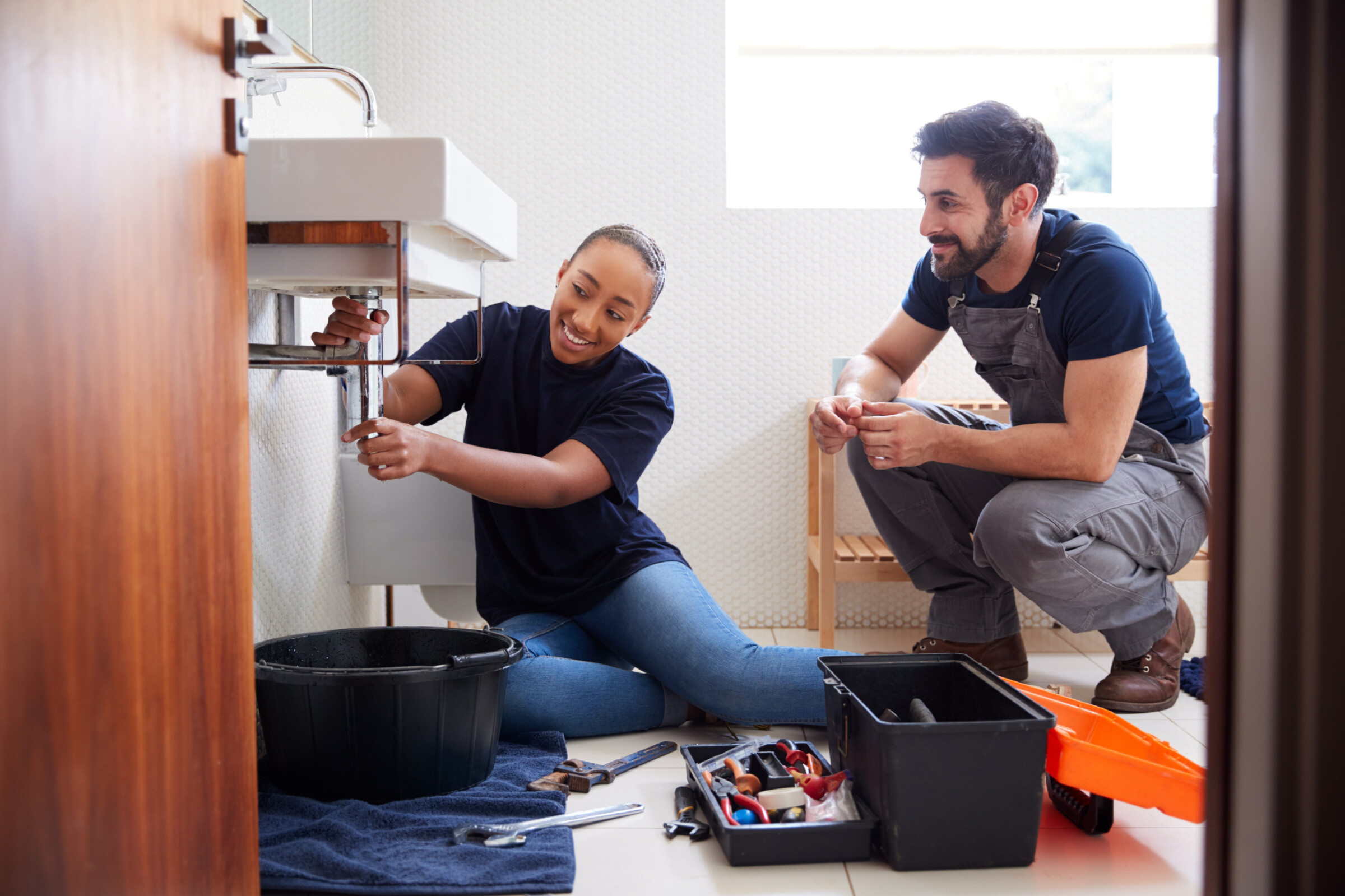 Lady plumber assisting a customer in the bathroom