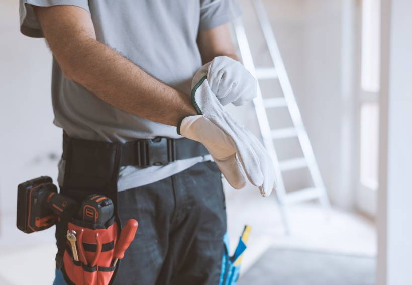 handyman vs. contractor - a handyman putting on white gloves