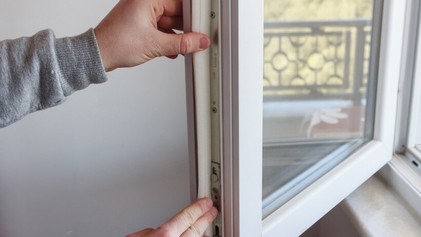 foam weather stripping vs vinyl: a man installing weather stripping for weather protection