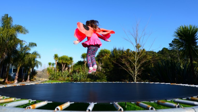 rectangle vs round trampoline: a dressed up as little girl bounces and jumps on a round trampoline