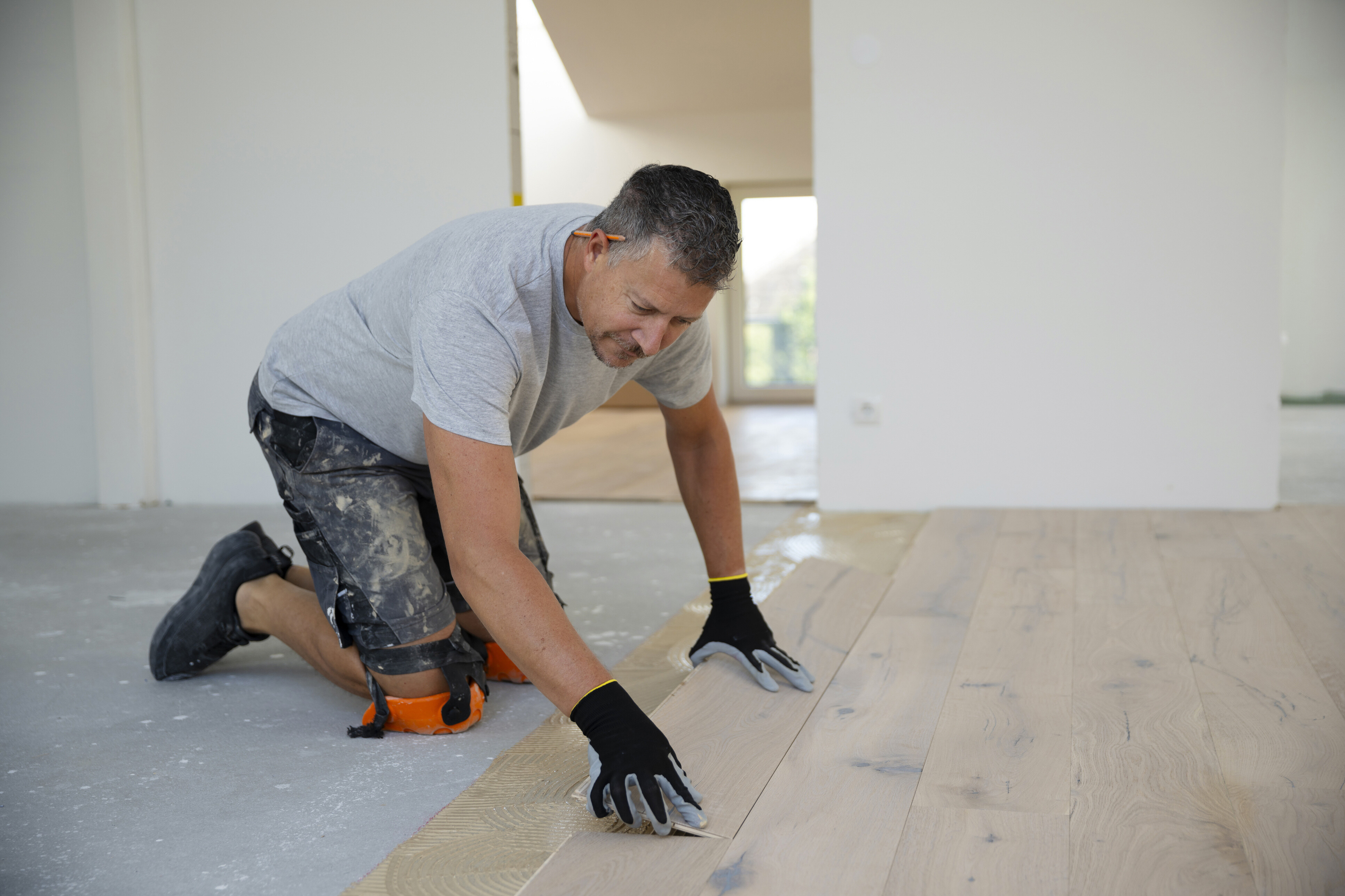 A flooring expert installing timber floor panels.