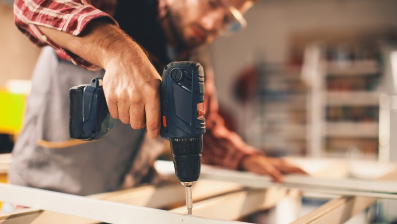 Impact driver vs drill - A handyperson working with drill in the workshop