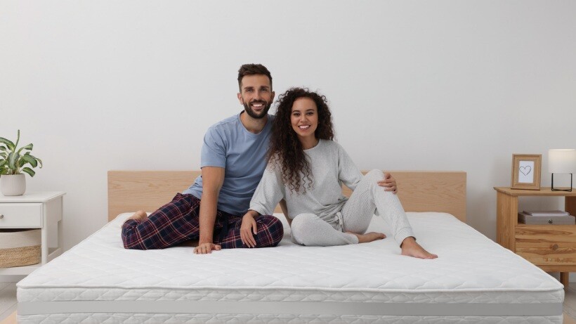 Double bed vs queen bed vs king bed - Happy couple on bed with comfortable mattress at home