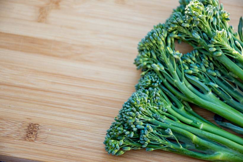 broccoli vs broccolini - fresh broccolini on a wooden board