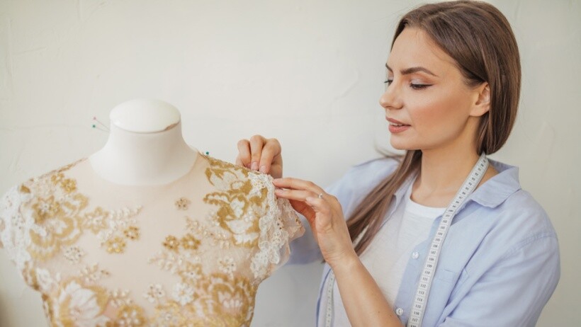 Seamstress vs tailor - A seamstress working with a wedding dress in a studio