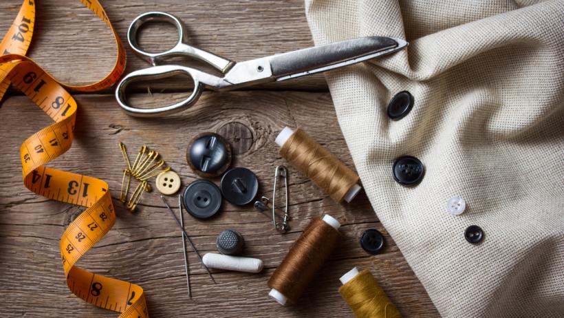 Seamstress vs tailor - Variety of sewing supplies arranged on a table.