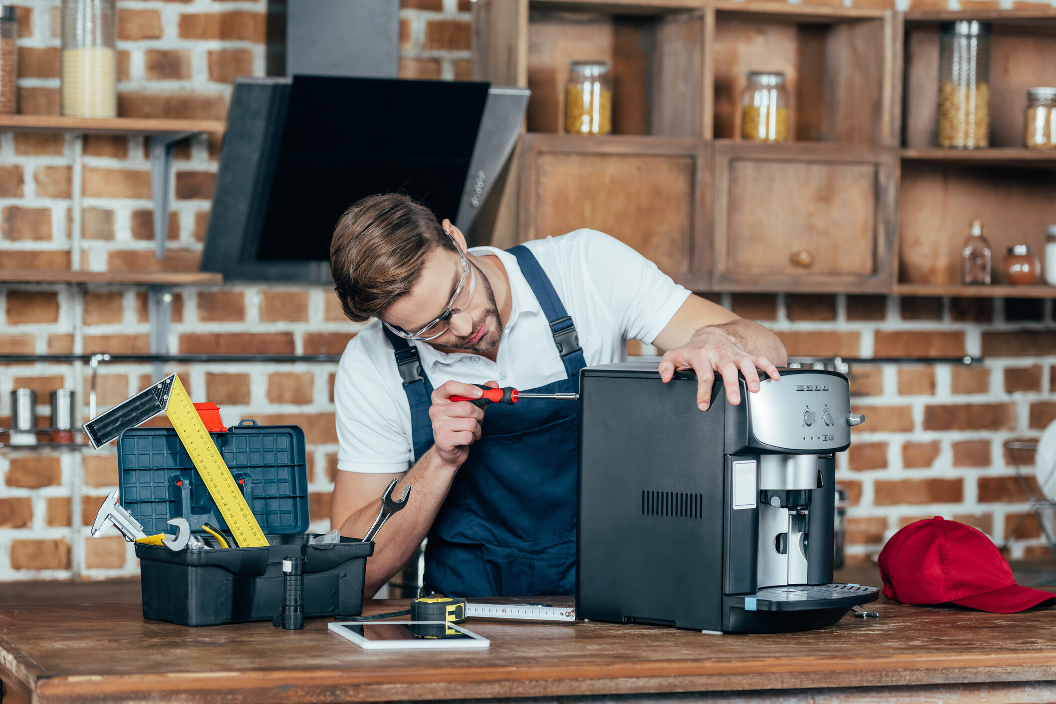 A professional worker making repairs on a broken coffee machine.