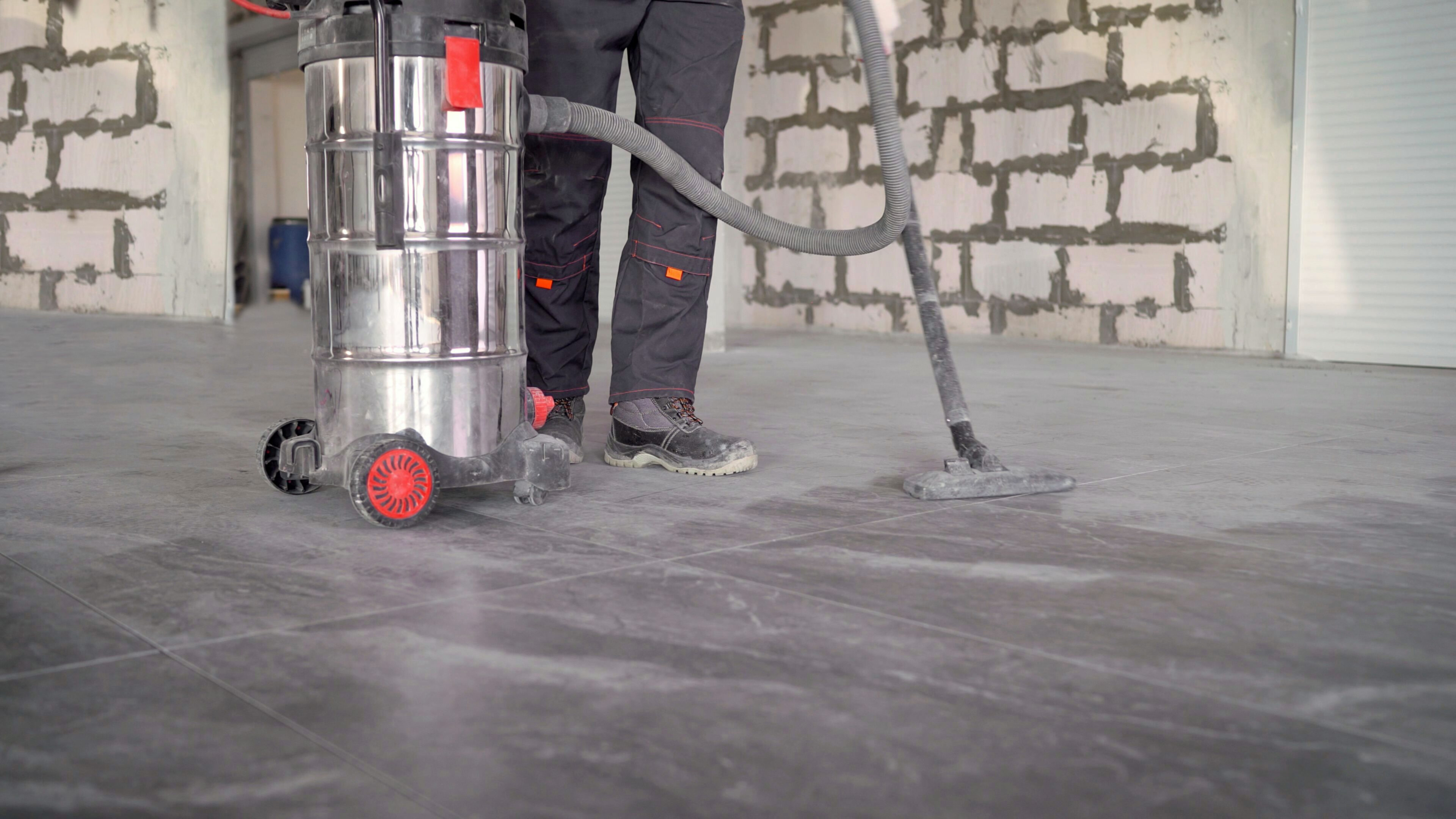 A professional worker cleaning a concrete floor.