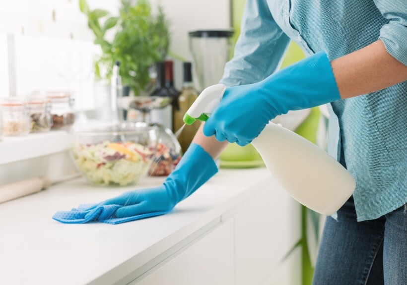 Isopropyl Alcohol vs Ethanol - A cleaner cleaning the kitchen with alcohol in a spray bottle.