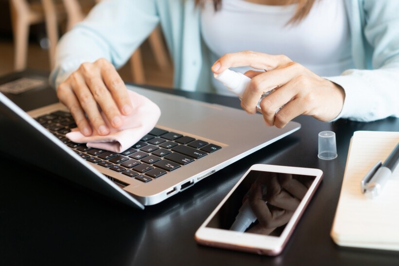 Isopropyl Alcohol vs Ethanol - A woman disinfecting her gadgets using isopropyl alcohol and a clean cloth.