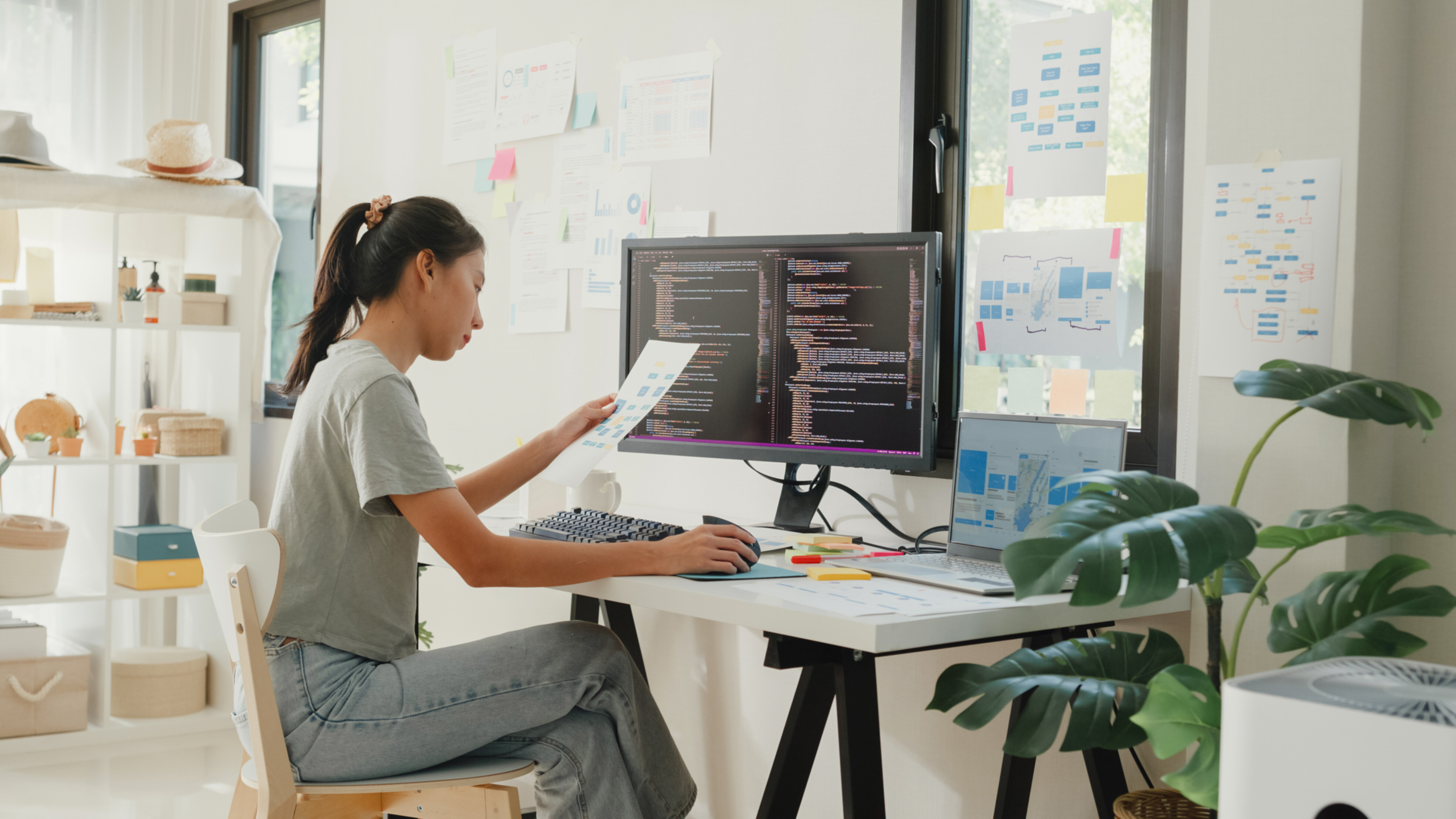 An Asian female web developer concentrating in her work space.