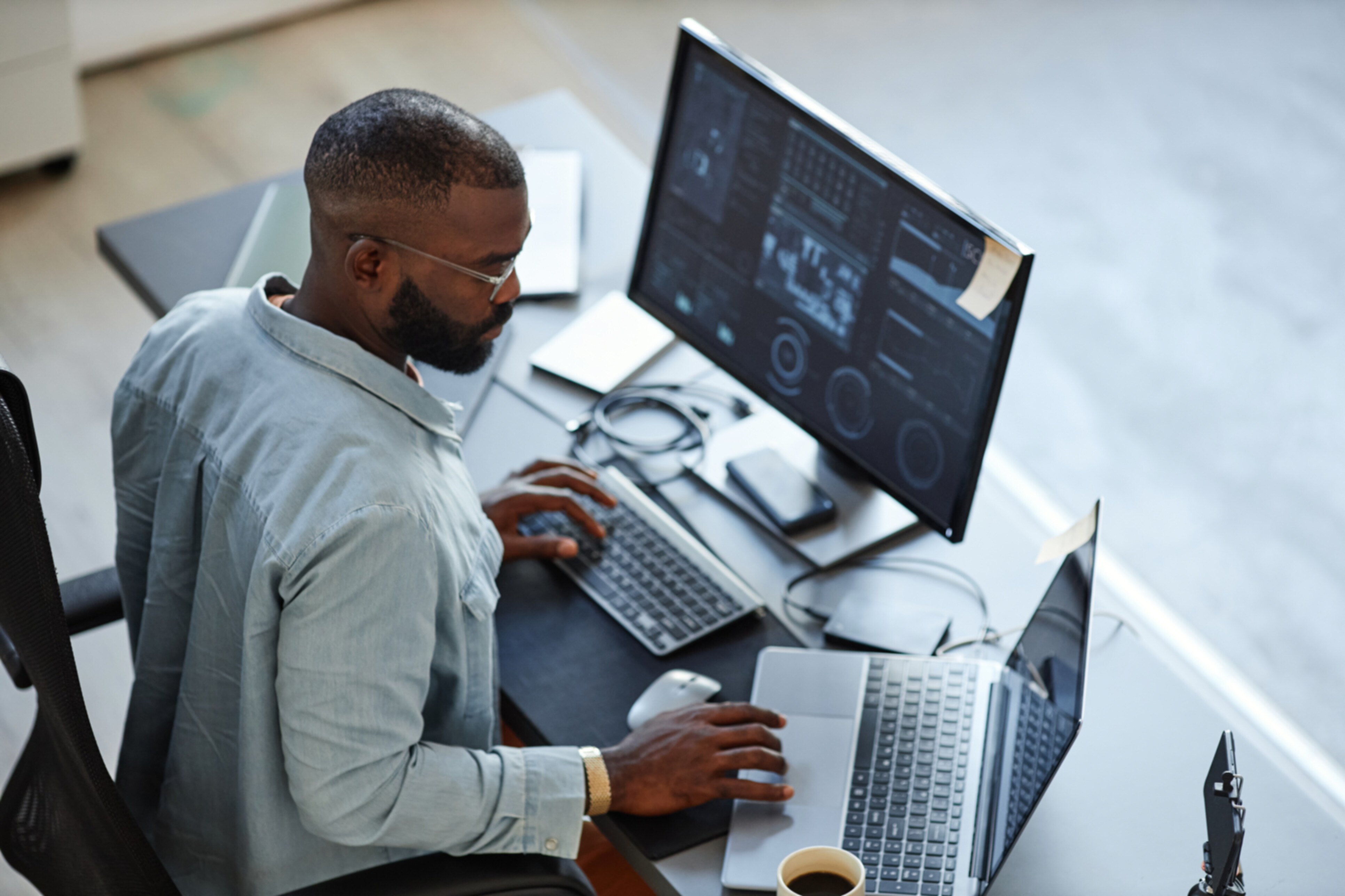 Top view of an African american programmer working on his desk.