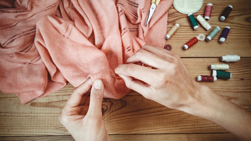 Hand sewing vs machine - A person hand-sewing clothes