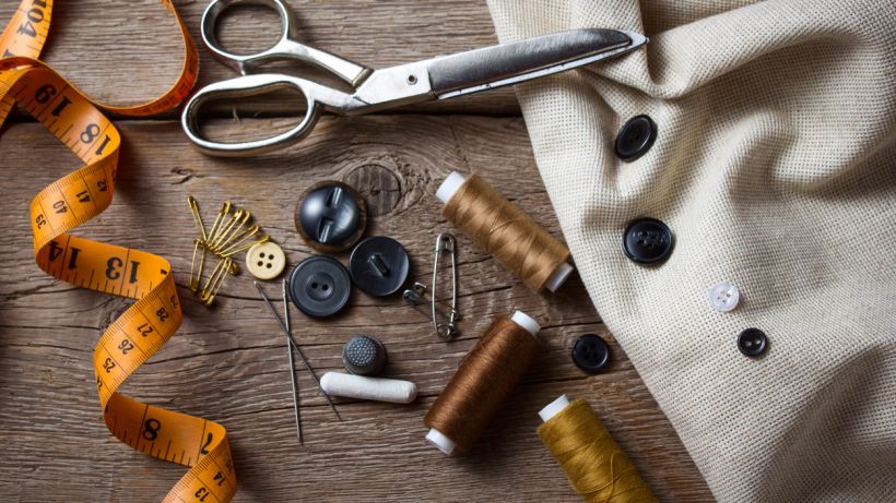 Hand sewing vs machine - Sewing accessories on a wooden table