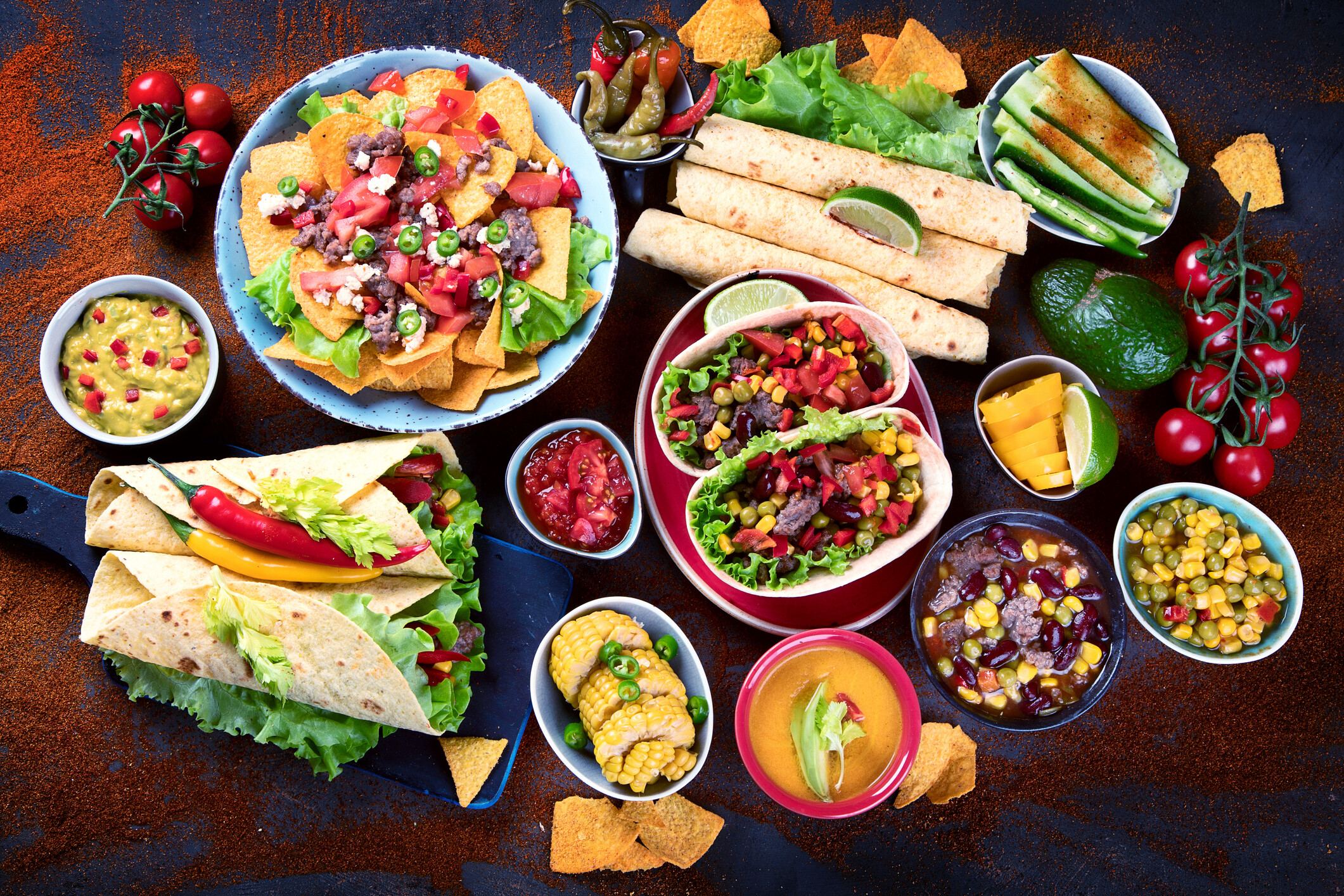 A Mexican food spread of tacos, nachos, wraps, and salsa ready for delivery.