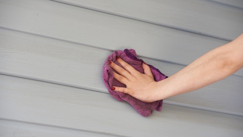 Wall cladding vs wall panelling - Close-up of hands cleaning wall panelling