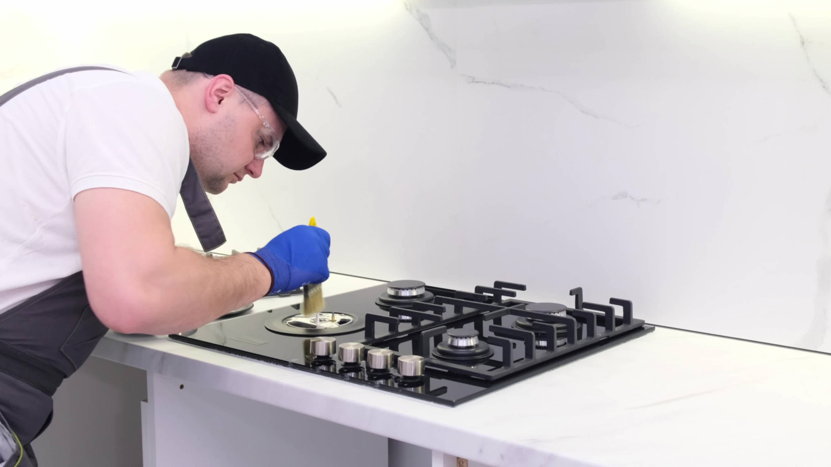 Technician performing gas stove installation and repair, ensuring proper safety and precision for a modern kitchen setup.