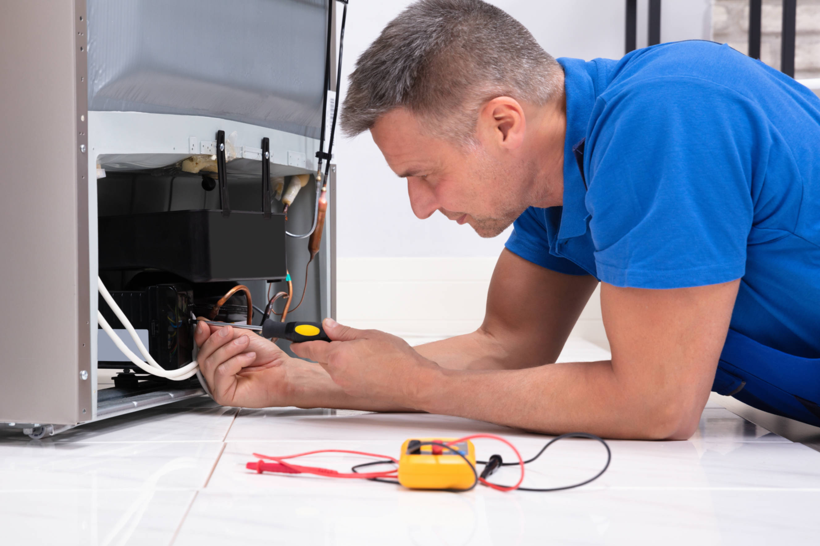 Technician performing ice machine repair and installation, fixing internal components of an appliance to ensure optimal functionality in a kitchen.