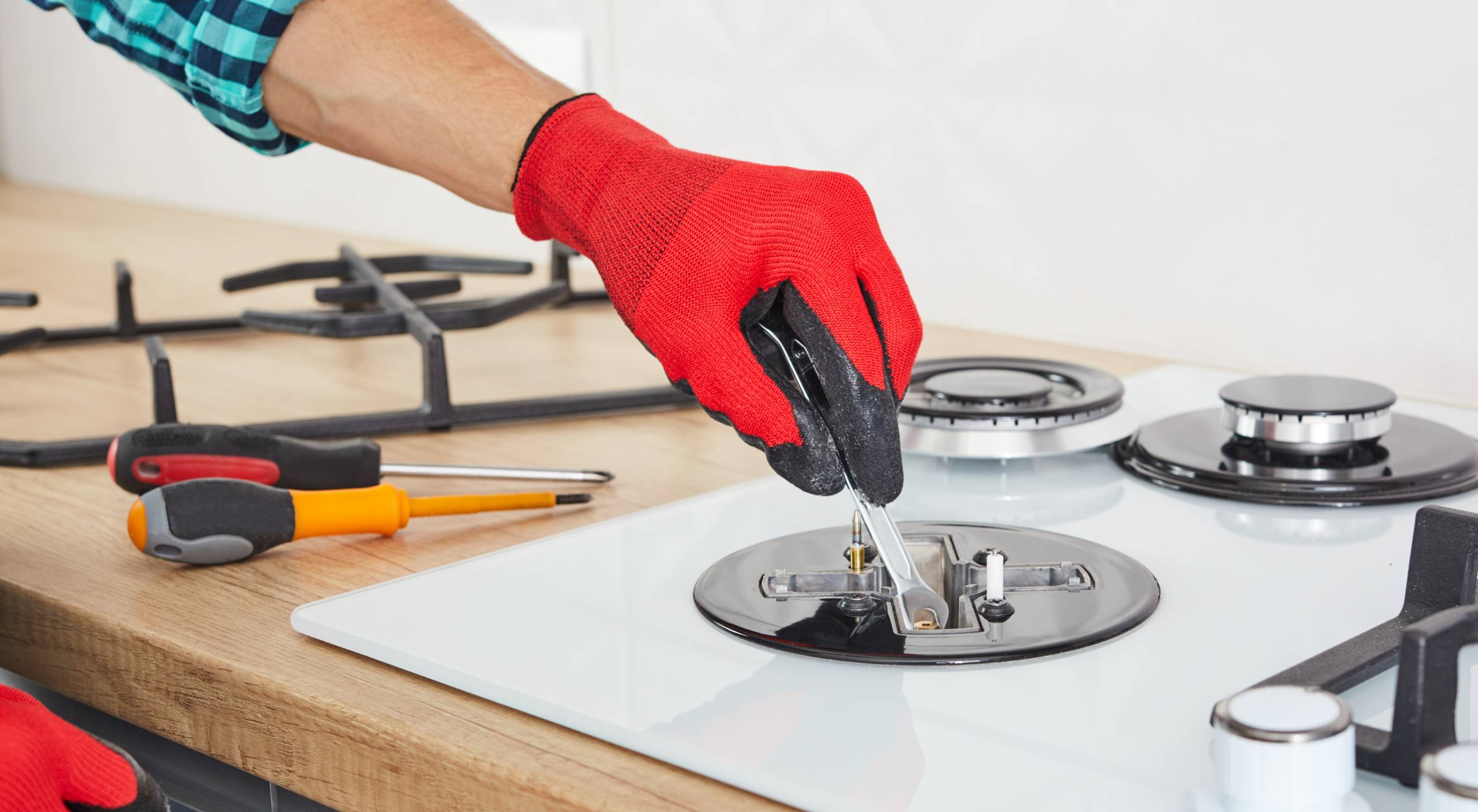 A handyperson using tools to install a cooktop.