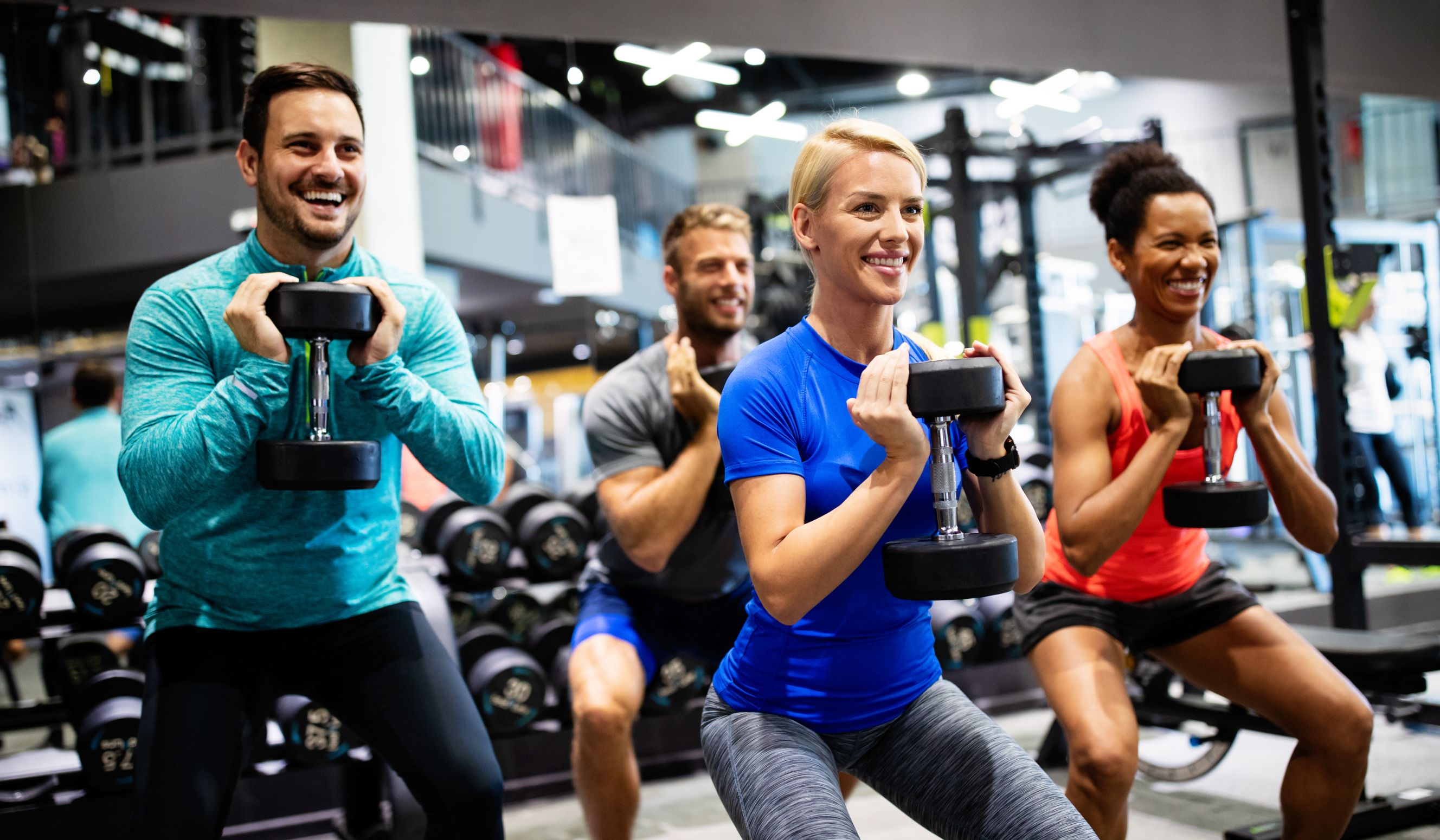 A group fitness session taking place in a well-equipped gym environment