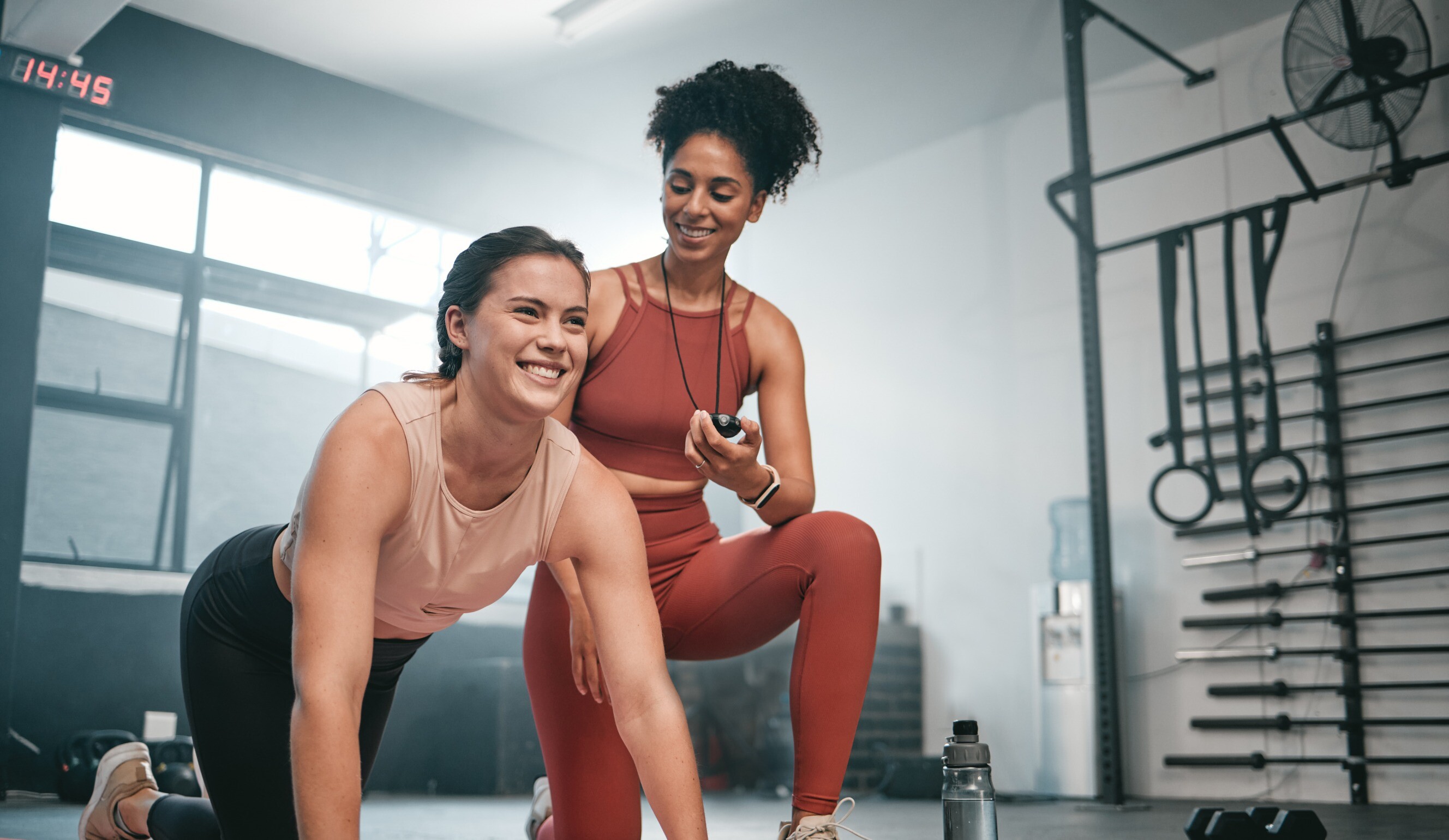 Two women engaged in a personal training session at a gym