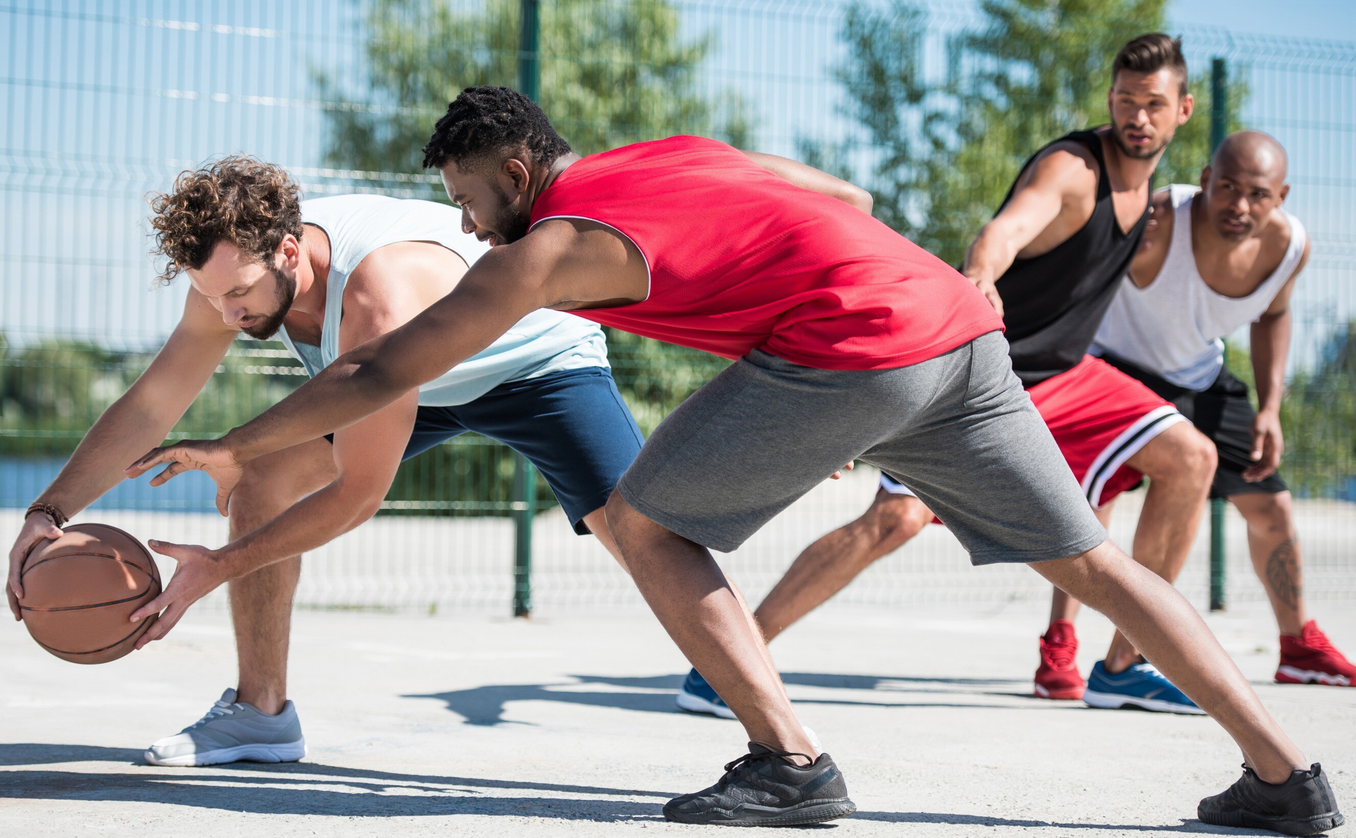 A group of men engaged in a basketball training session on an outdoor court