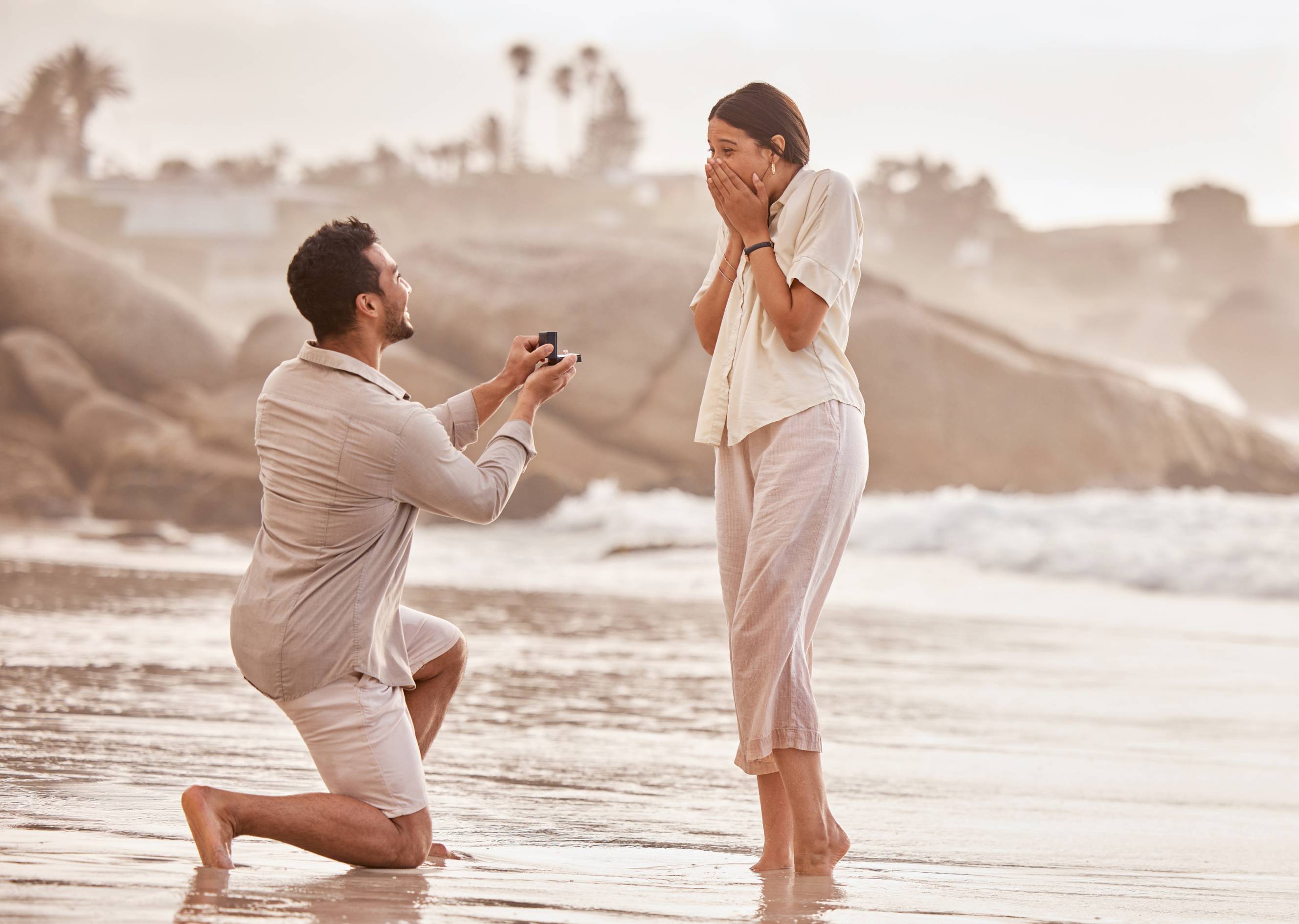 An engagement photographer took a photo of a couple's proposal on the beach.