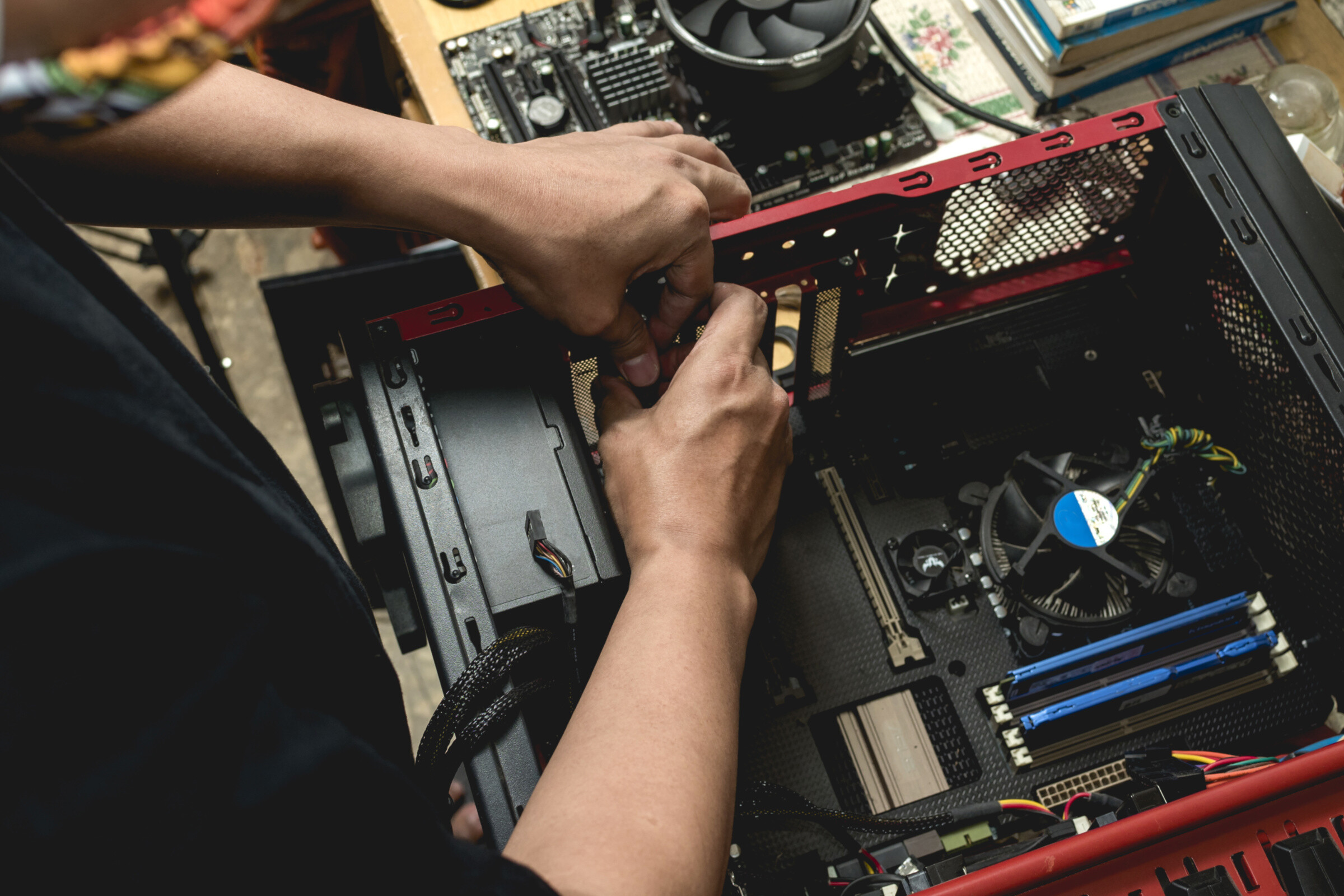 A shot of a technician's arms as he makes repairs on a computer.