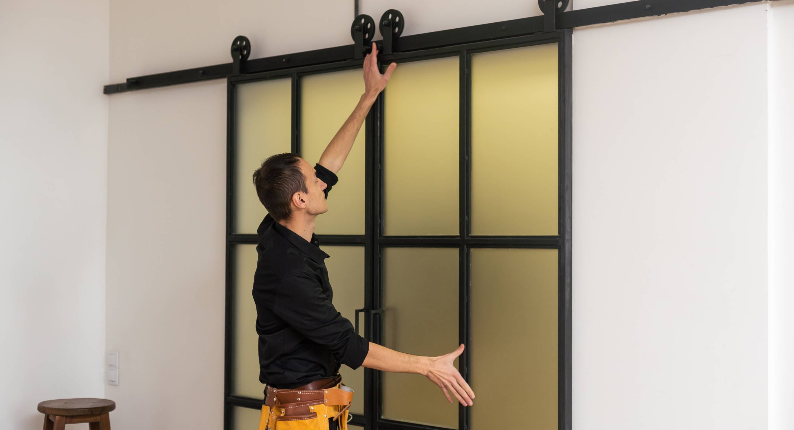 A handyman hanging an interior door for a modern home design.