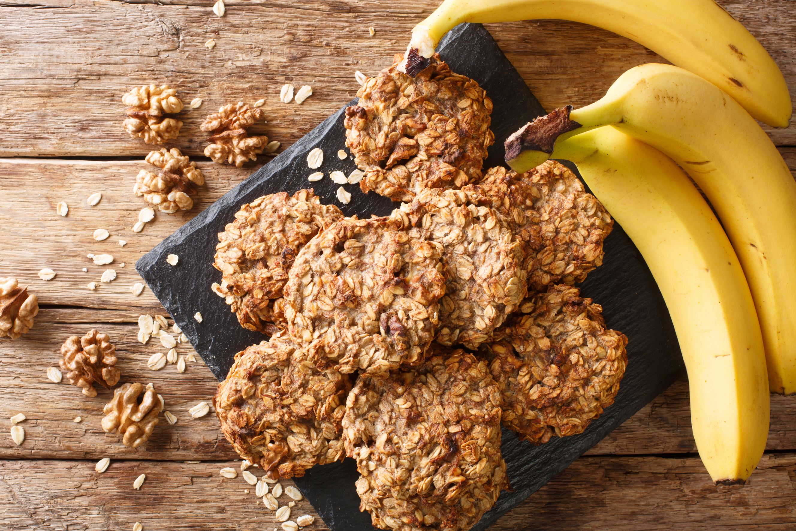 A picture of oatmeal cookies and a banana representing vegan baking.