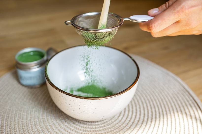 hojicha vs matcha - sifting matcha powder before whisking