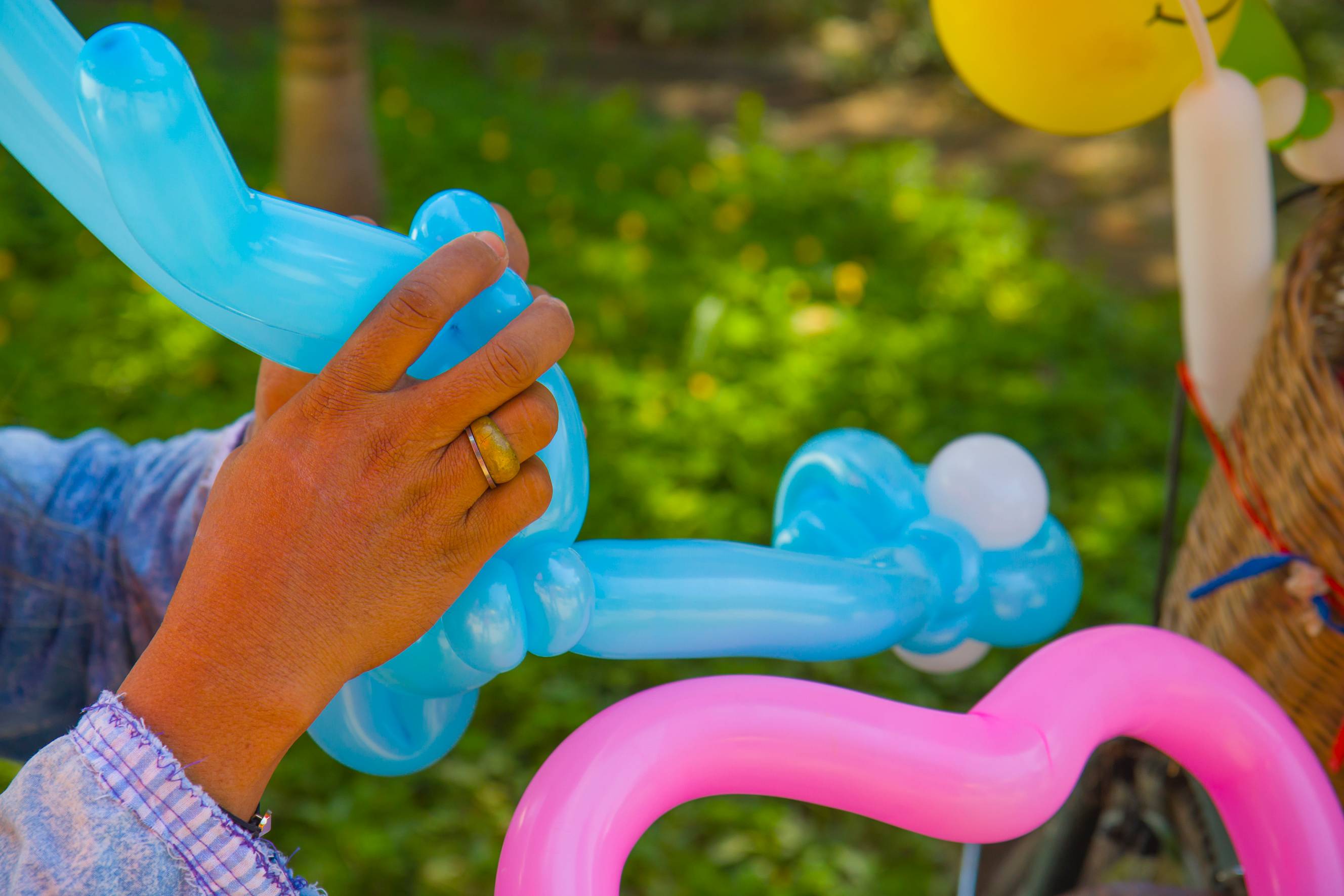 A balloon artist creating different shapes of balloons for entertainment at an event.