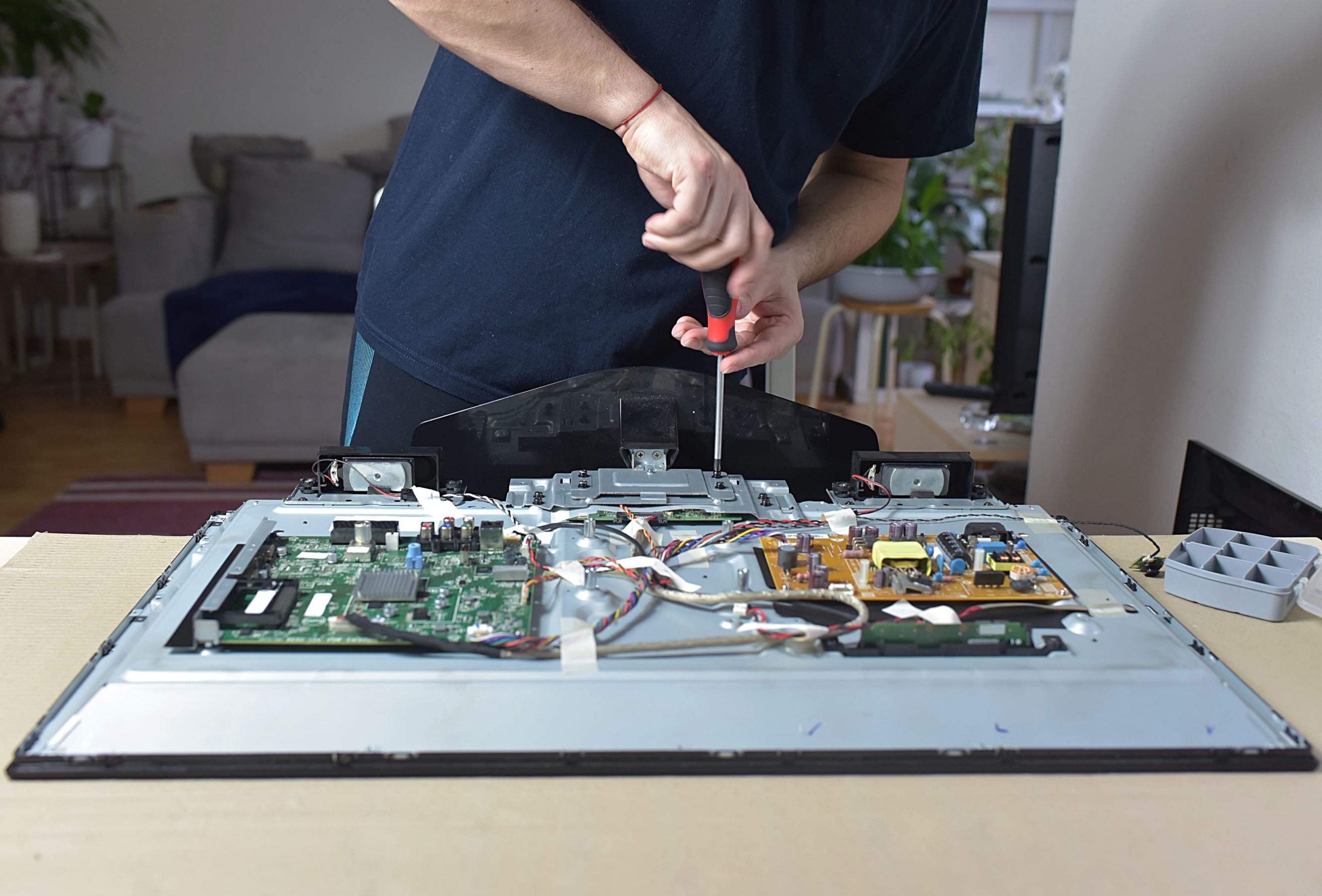 A man repairing a broken tv at home symbolizing Samsung appliance repair.