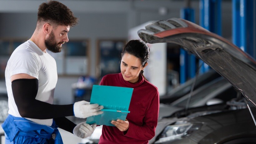 Car detailing vs car wash - Two mechanics reviewing paperwork and discussing a car service