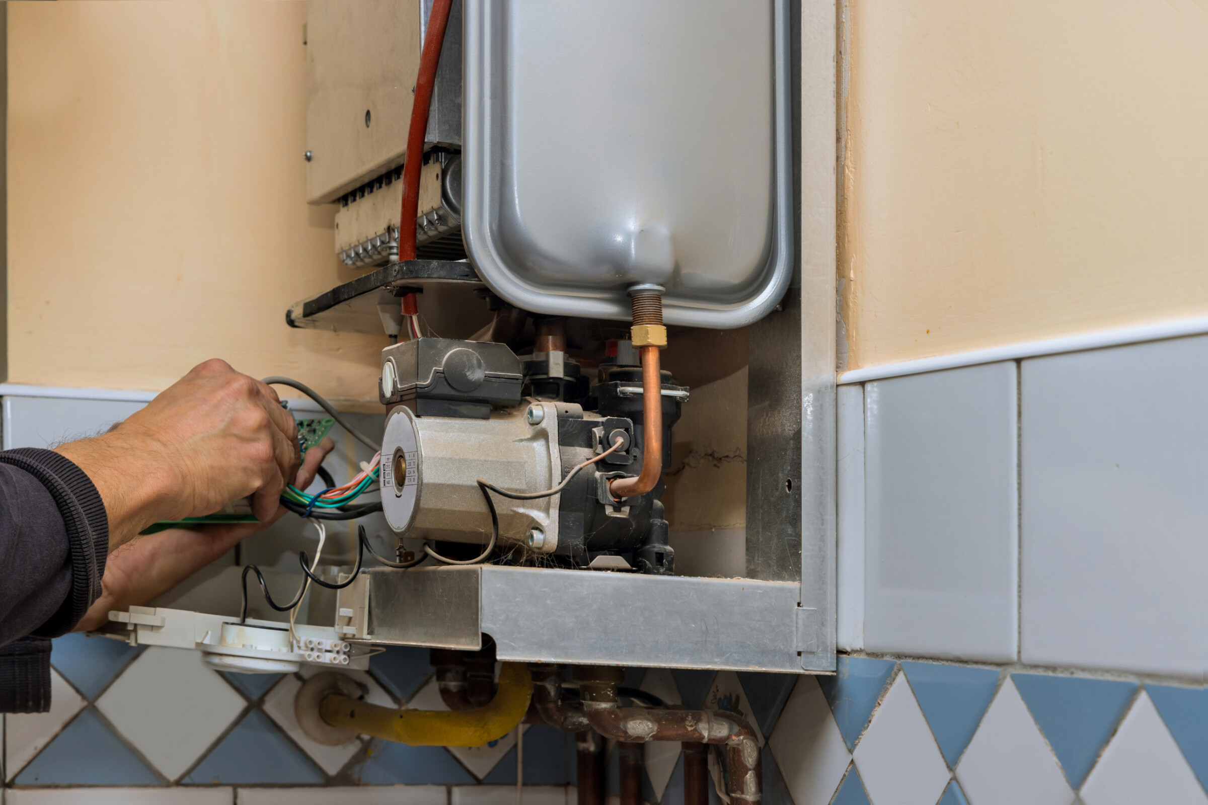 A service technician repairing a combi boiler.