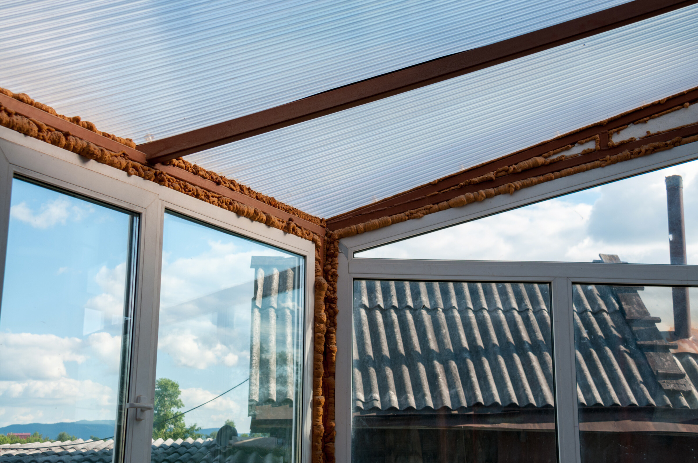 A conservatory with exposed insulation at the corners of the walls and roof.