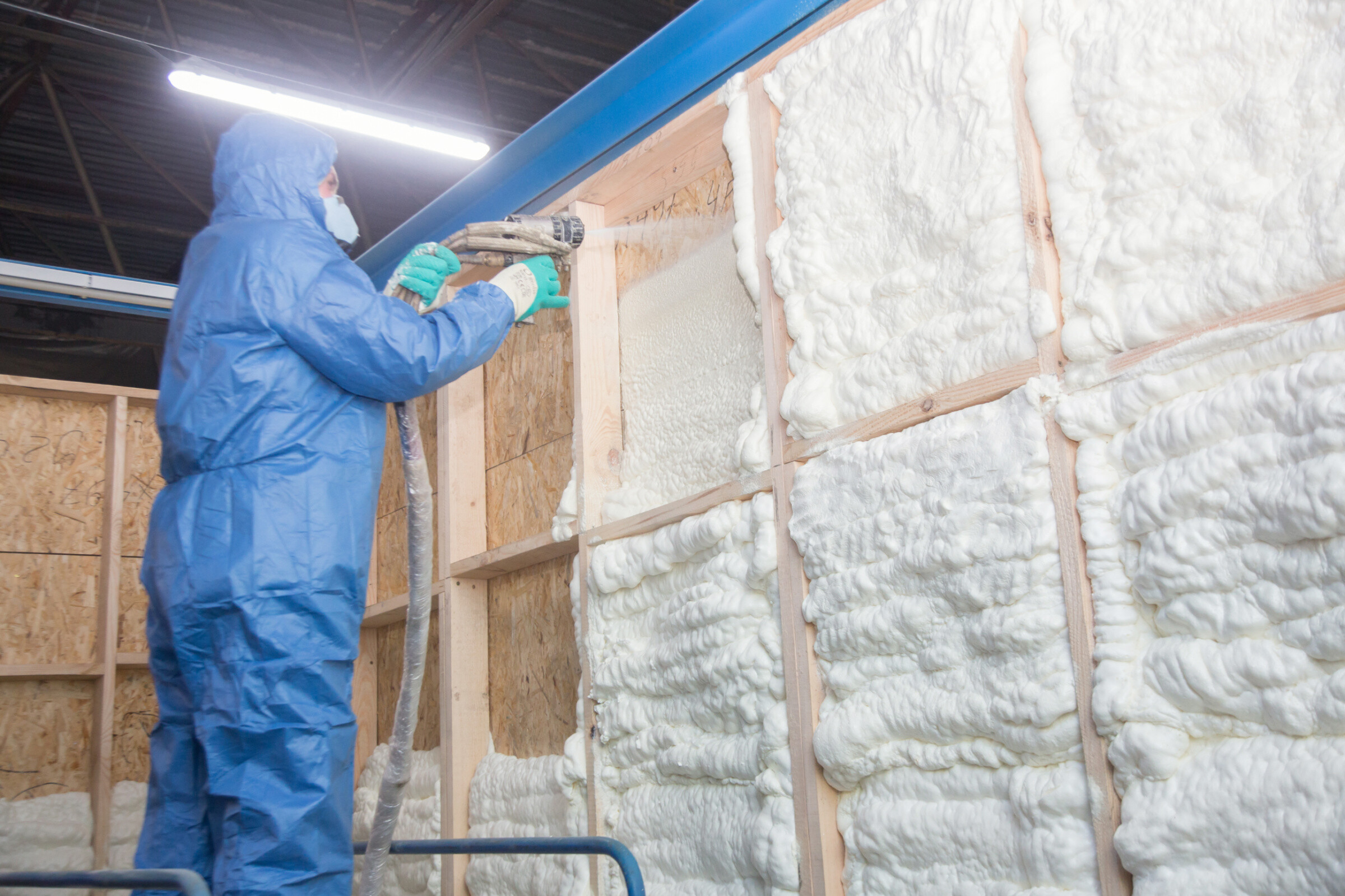 A professional worker applying spray foam insulation to the walls. 