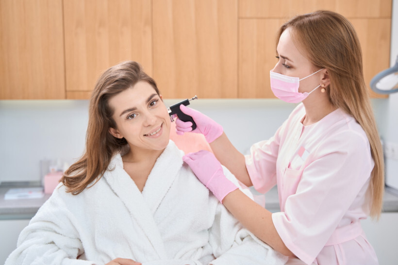 ear piercing cost - woman smiling with her piercer during ear piercing